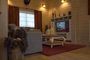 a living room with a couch and a table and a tv at Durbuy Villa Valentina in Durbuy