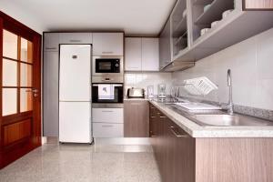 a kitchen with a white refrigerator and a sink at Simão House in Calheta