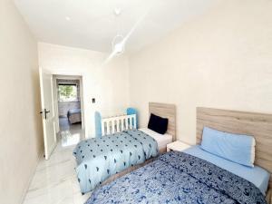 - une chambre avec 2 lits et un lit bébé dans l'établissement Green Family House 3 Bedrooms with Garden View Casablanca, à Casablanca