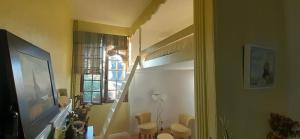 um quarto com uma escada com cadeiras e uma janela em Maison d'Hôtes Archangels Home em Saint-Saëns