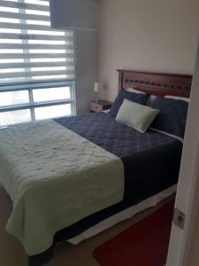 - une chambre avec un lit doté d'un oreiller et d'une fenêtre dans l'établissement Acogedor Departamento en El Tabo, à El Tabo