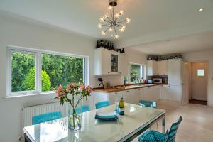 kuchnia ze szklanym stołem i niebieskimi krzesłami w obiekcie Finest Retreats - The View w mieście Shaldon
