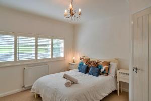 sypialnia z dużym białym łóżkiem z niebieskimi poduszkami w obiekcie Finest Retreats - The View w mieście Shaldon