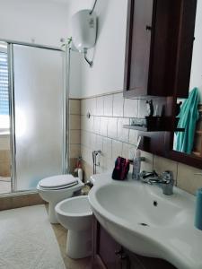 y baño con lavabo, aseo y ducha. en casa Rituzza, en San Leone