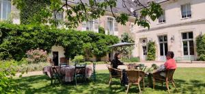 two women sitting at tables in the yard of a house at Château de Thouaré in Thouaré-sur-Loire