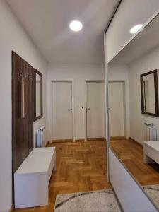 Una habitación grande con puerta de cristal y suelos de madera. en Apartman Tesla Pale, en Pale