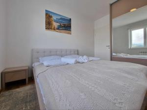 1 dormitorio con 1 cama blanca grande y espejo en Apartman Tesla Pale, en Pale