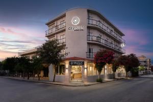 罗德镇City Plus Rhodes Hotel的街道边有商店的建筑物