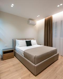 a bedroom with a large bed and a window at Arkle Apartments 3 in Tirana
