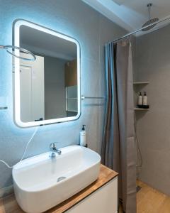 a bathroom with a sink and a mirror and a shower at Arkle Apartments 3 in Tirana