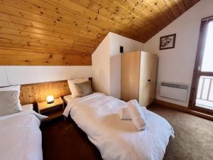 2 camas en una habitación con techo de madera en Chalet Schuss, en Landry