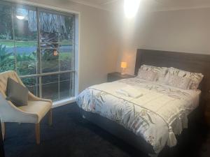 een slaapkamer met een bed, een raam en een stoel bij Geelong Bellarine Coastal Stays#Pet Friendly in Clifton Springs