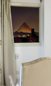 a window with a view of the pyramids at الجيزه هرم شارع ابو الهول السياحي in Cairo