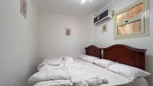 a bedroom with two beds with white sheets and a window at الجيزه هرم شارع ابو الهول السياحي in Cairo