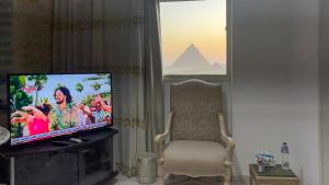 a living room with a tv and a chair and a pyramid at الجيزه هرم شارع ابو الهول السياحي in Cairo