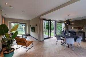 een eetkamer en een woonkamer met een tafel en stoelen bij De Witte Bergvliet in Oosterhout