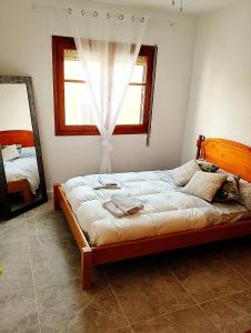a bedroom with a bed with a window and a mirror at ATICO ESTUPENDO in Calabardina