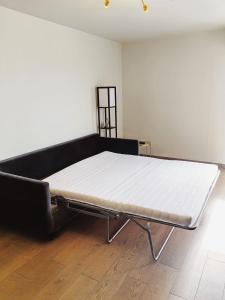 Ce lit se trouve dans un dortoir doté d'un matelas blanc. dans l'établissement Paris La Defense - Courbevoie vue sur Seine, à Courbevoie