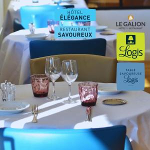 a table with two wine glasses on it at Le Galion Hotel et Restaurant Canet Plage - Logis in Canet-en-Roussillon