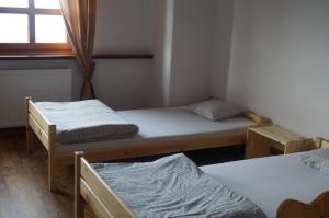 Habitación con 2 camas individuales y ventana. en Schronisko PTTK Hala Szrenicka en Szklarska Poręba