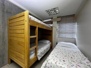 Hospedagem BRASILIANAS في برازيليا: غرفة نوم مع سرير بطابقين بجوار سرير six sidx