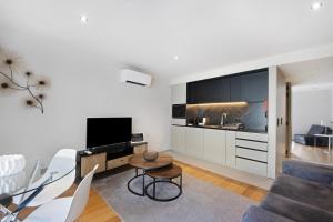 un soggiorno con divano, tavolo e TV di Morgado Granja Luxury Suites ad Aveiro