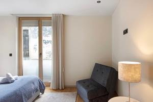 una camera con letto, sedia e lampada di Morgado Granja Luxury Suites ad Aveiro