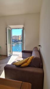 a couch in a room with a view of a pool at Attico vista mare mozzafiato in Porto Santo Stefano