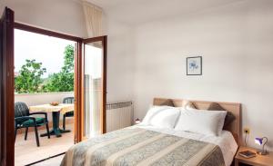 a bedroom with a bed and a balcony with a table at B&B Moderno in Fažana