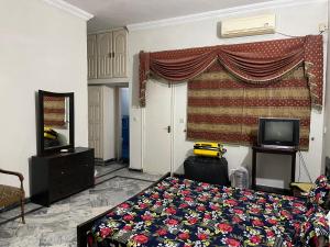 een slaapkamer met een bed en een televisie. bij Islamabad lodge in Islamabad