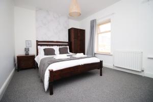 ein Schlafzimmer mit großem Bett und Fenster in der Unterkunft Central Cardiff - 3 Bedroom Home - Walk to Shopping Town Centre And Cardiff Castle in Cardiff