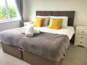 a bedroom with a large bed with two towels on it at 3-bedroom home with Breakfast, PS4 & Private parking in Swansea