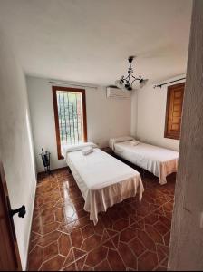 um quarto com duas camas e uma janela em Cortijo Cantalobos em Almuñécar