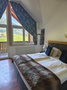 a bedroom with two beds and a large window at Appartements Alpengarten in Mallnitz