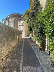 an alley with a stone wall and a building at A CASA ROSSA , La Marjolaine in Saint Paul de Vence