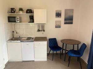 a small kitchen with a table and blue chairs at Haus Osterstraße in Norden