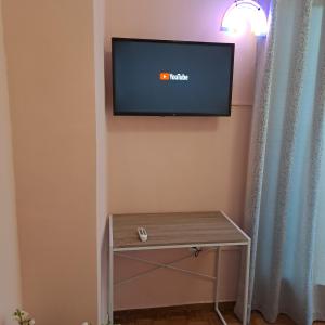 a flat screen tv on a wall with a table at Riga Fereou apartments in Patra
