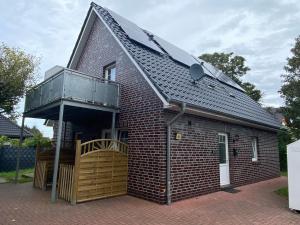 a small brick house with a balcony on it at Haus Osterstraße in Norden