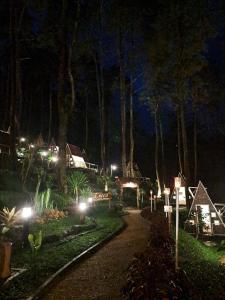 a walkway at night with lights in a forest at Locca Lodge in Mojokerto