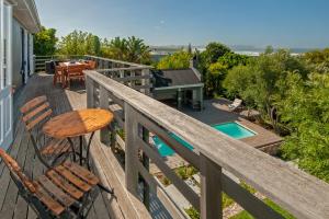 una terrazza con tavolo, sedie e piscina di Villa Blu Guesthouse a Hermanus