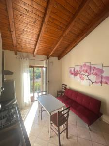 - un salon avec un canapé rouge et une table dans l'établissement Il Nido dell’Aquila, à Moncalvo