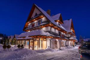 un gran edificio cubierto de nieve por la noche en Parzenica B&B, en Białka Tatrzanska