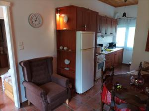 a kitchen with a chair a table and a refrigerator at ELLI΄S HOUSE ΣΥΓΧΡΟΝΟ ΣΠΙΤΙ ΣΤΑ ΠΡΑΜΑΝΤΑ in Pramanta +31 photos