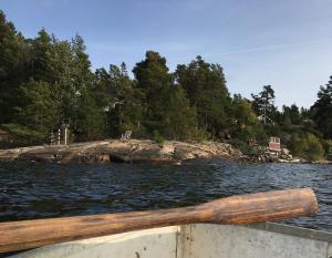 een houten peddel op een boot in een lichaam van water bij Sjöstuga, Archipelago Beach House in Värmdö