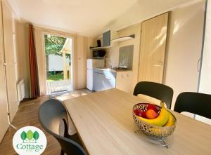 a bowl of fruit on a wooden table in a kitchen at Cottage C17 – proche Europapark in Boofzheim