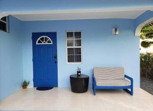 a blue wall with a chair and a blue door at La Casita Azul in Castries