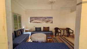 uma sala de estar com dois sofás azuis e uma mesa em Myhouse Todgha em Tinghir