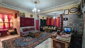 uma sala de estar com um sofá e uma televisão em Myhouse Todgha em Tinghir