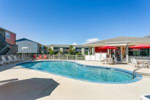 a swimming pool with tables and chairs and umbrellas at Villas on the Gulf #N1 in Pensacola Beach
