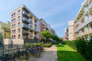 een rij fietsen geparkeerd voor de gebouwen bij Beautiful Apartment with Spacious Balcony by Renters in Wrocław